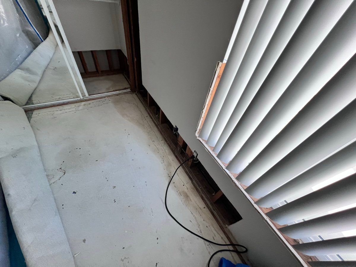 Framing exposed after flood-damaged drywall removal, prepared for drying in a San Diego property